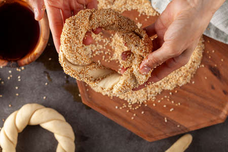 delicious Turkish bagel with sesame seeds known as susamli simit. top view image shows shaping the...