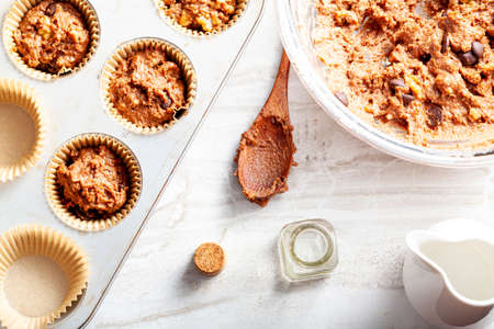 Top view image showing making of delicious fruit and nut cupcake on white marble countertop...
