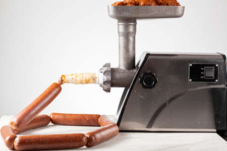 Close up isolated image of homemade sucuk or Sausage that is being stuffed into casing using electrical stuffer device.の写真素材