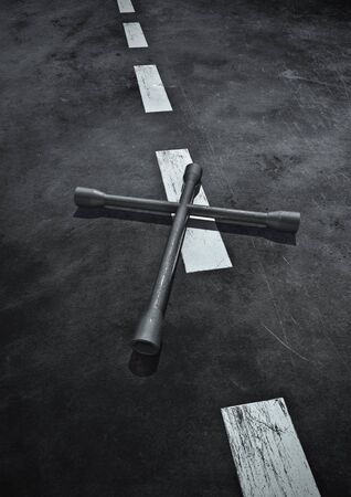 Road safety  3D render of cross shaped tire iron on road surfaceの写真素材