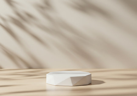 A clean white pedestal sits on a light-colored surface, bathed in soft sunlight casting leaf-like shadows on a textured wall.の素材