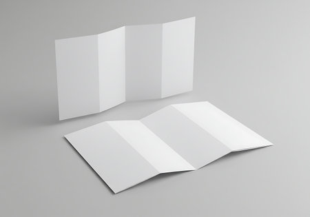 Two blank tri-fold brochures are displayed on a minimalist gray surface, ready for your design.の素材