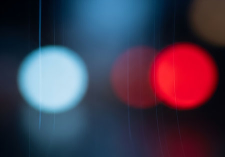 Blurred circles of vibrant red and cool blue light create an abstract, dreamy background effect.の素材