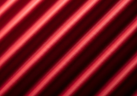 A close-up abstract view of bright red diagonal lines against a dark background, creating a vibrant light texture.の素材