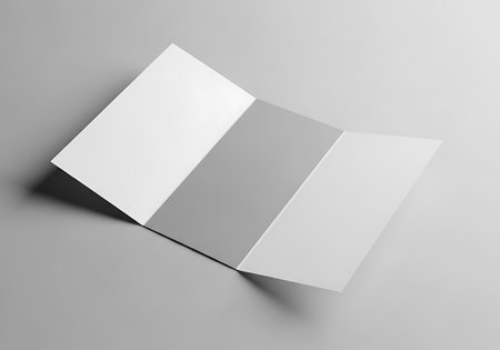 A clean, white tri-fold brochure is presented open on a neutral gray background, ready for design.の素材