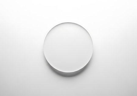 A simple, elegant oval mirror sits centered on a bright white surface, offering a clean and modern aesthetic.の素材