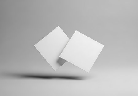 A minimalist scene featuring two empty white square cards suspended in the air against a neutral gray backdrop.の素材