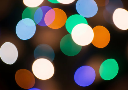 A vibrant and blurry display of colorful circular lights creating a festive and abstract bokeh effect.の素材
