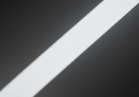 A stark white line cuts diagonally across a dark, grainy, textured surface, creating a bold abstract composition.の素材