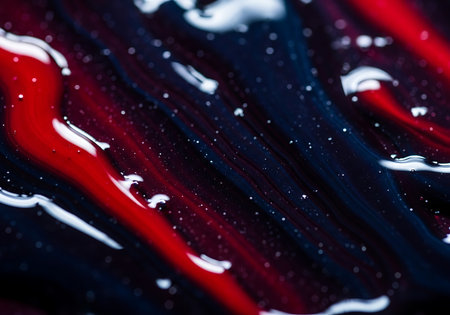 A close-up abstract view of swirling red and dark blue colors with small white speckles and highlights.の素材