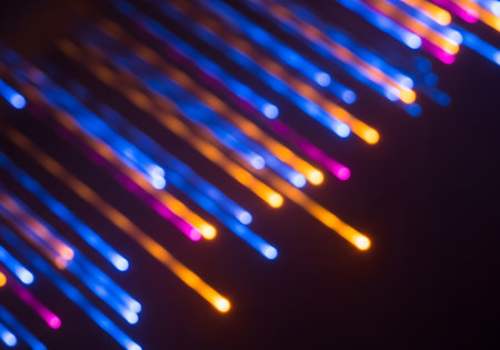 Diagonal streaks of vibrant blue, orange, and purple bokeh lights create an abstract, energetic background.の素材