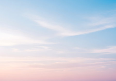 A serene sky painted with gentle pastel hues of pink, orange, and blue, featuring delicate, wispy clouds.の素材
