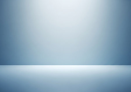 A minimalist, cool-toned studio backdrop with soft spotlighting and a reflective floor surface.の素材