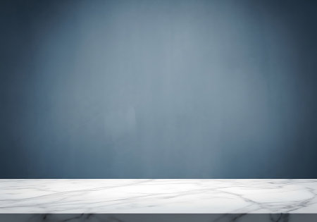 A clean, empty marble countertop or table surface in the foreground with a subtly textured blue wall behind it.の素材