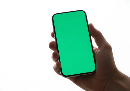 A person's hand grips a sleek mobile device displaying a vibrant green display against a clean white background.の素材