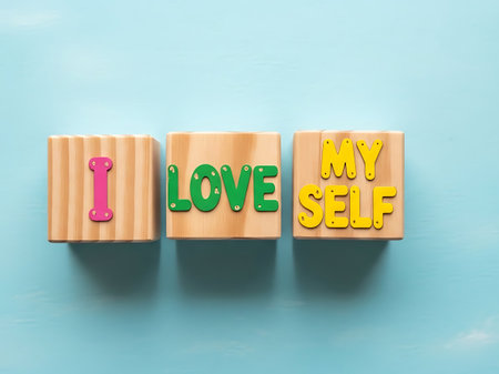Three wooden blocks with colorful letters spelling 'I Love Myself' against a blue background, symbolizing self-love and positivity.の素材