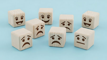 This image features a collection of wooden cubes, each carved to display a different facial expression. The cubes are arranged on a light blue background, showcasing a range of emotions from happiness to sadness, surprise, and anger. The craftsmanship highlights the simplicity and expressiveness of these wooden figures.の素材