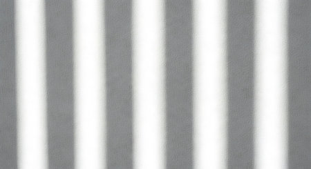 A close-up image of a gray and white striped pattern, featuring vertical stripes with a textured surface. The gray stripes have a rough, speckled appearance, while the white stripes are smooth and bright. The overall effect is a visually appealing and dynamic background.の素材
