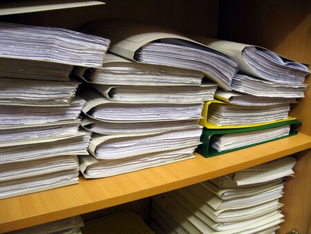 The office bookshelf with different documents, books and folders