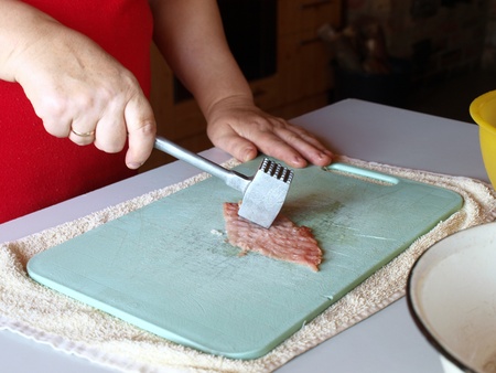Beating pork chop with special aluminum hammer       の写真素材