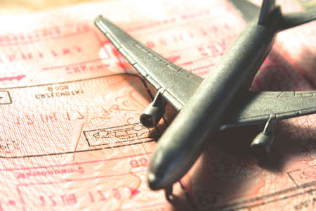 small toy airplane on a foreign passport, retro toned