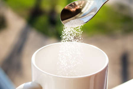 Pour sugar into a mugの写真素材