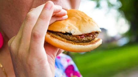 The girl is eating a burger