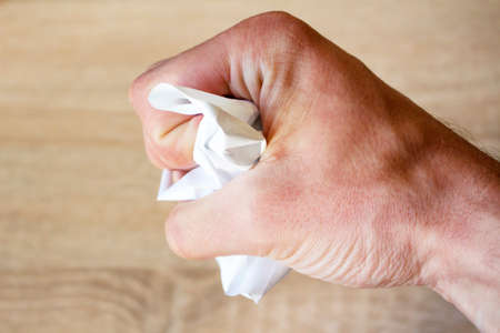 Crumpled scrap of paper in handの写真素材