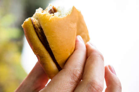 The girl is holding a burger in her hand