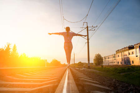 The girl is walking on rails toned