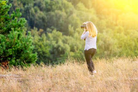 young girl takes pictures of beautiful nature tonedの写真素材