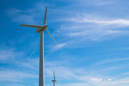 Blades of a wind farm against a blue sky