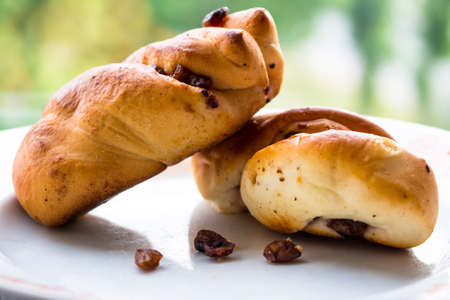 Soft fresh buns with raisins on a plateの写真素材