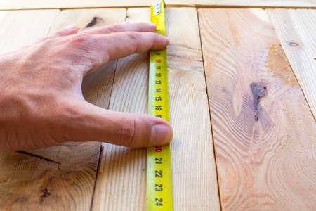 Measure with a tape measure on a wooden board