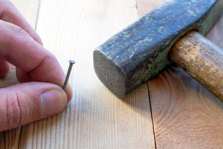Nail in the board and a hammer