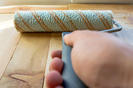 Paint roller on wooden boardsの写真素材