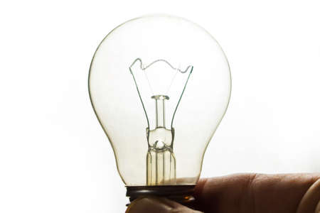 switched off incandescent lamp in hand