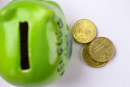 green piggy bank with coins