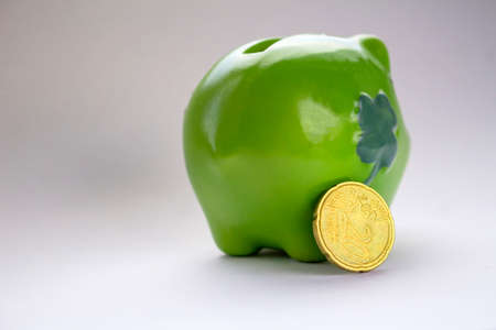 green piggy bank with coinsの写真素材