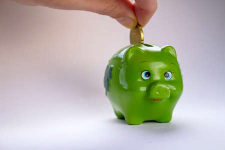 green piggy bank with coins
