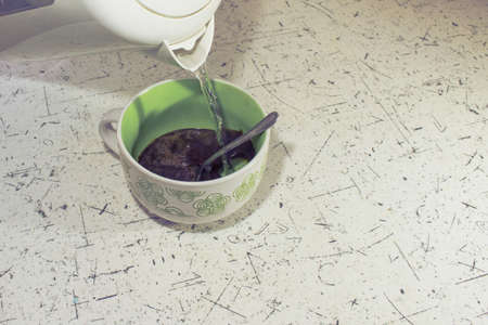 pour water into a mug of coffee toned