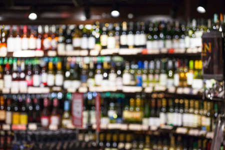 assortment of bottles of wine and alcohol in the store, blurred imageの写真素材
