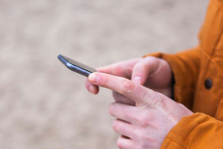 guy dials a message on the smartphone