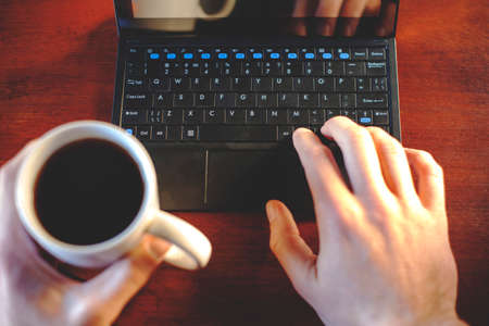 working behind laptop with a cup of coffee, retro tonedの写真素材