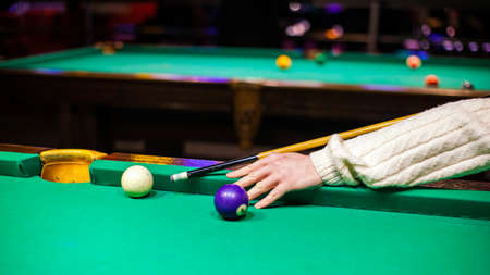 person plays billiards