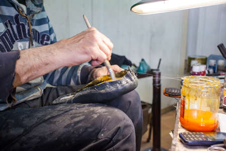 shoemaker repairs shoes in his workshopの写真素材