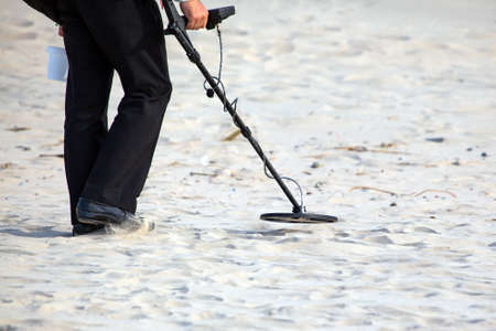 man on the beach with a metal detector