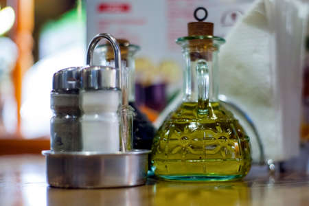 Salt, pepper and olive oil on a table in a restaurant
