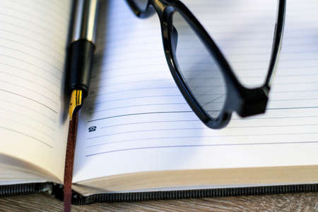 fountain pen and glasses lie on a notebook