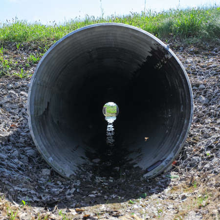view from the inside onto a large sewage pipeの写真素材
